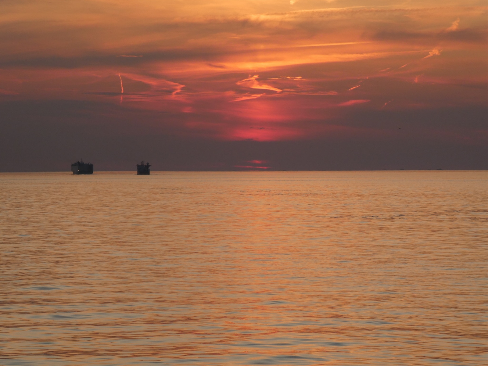 Vissersboten op de Noordzee tijdens zonsondergang.